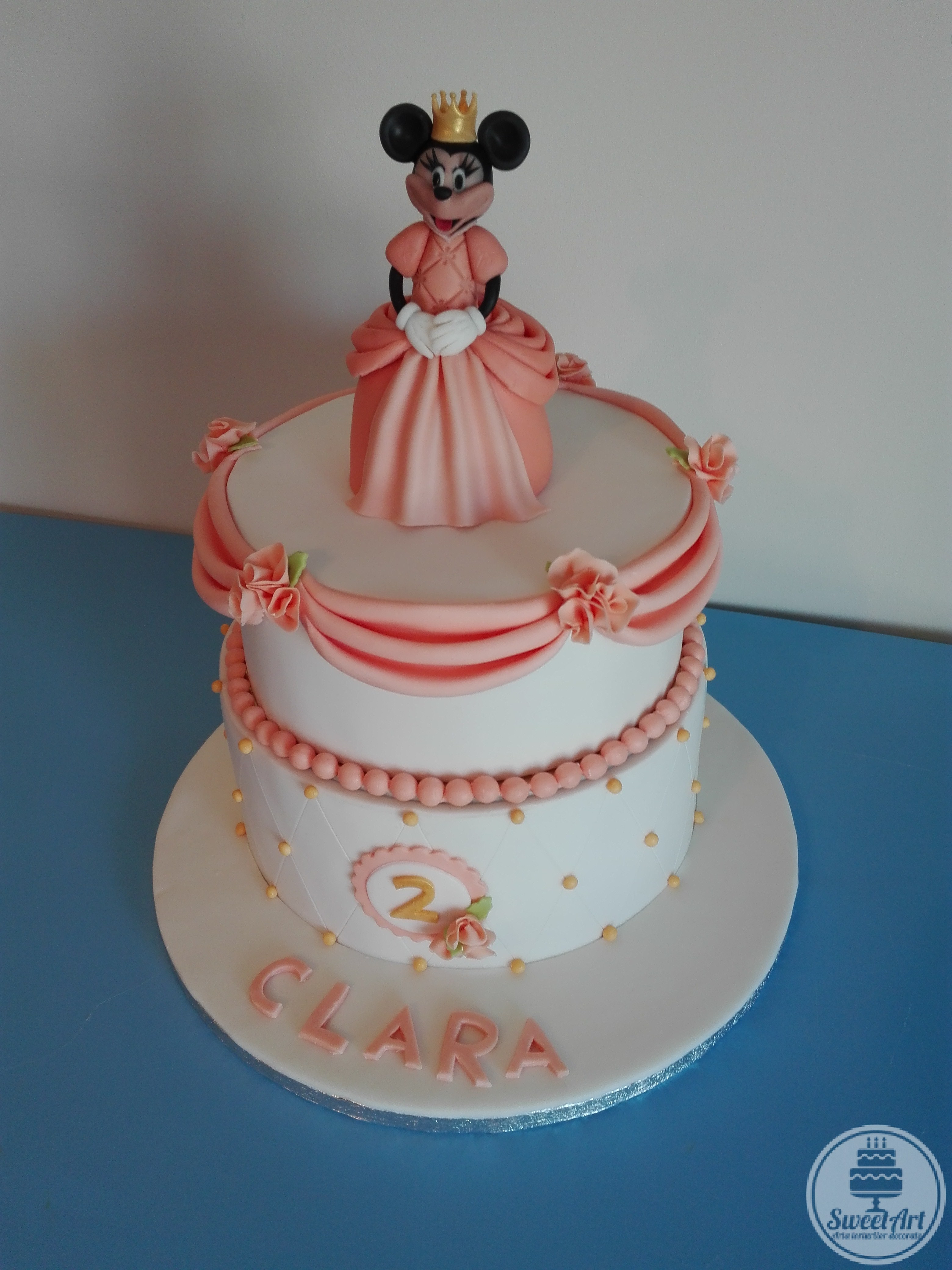 Tort cu Minnie Mouse prințesă; tort alb, elegant, prețios, cu falduri, trandafirași, romburi și mărgele roz corai pal