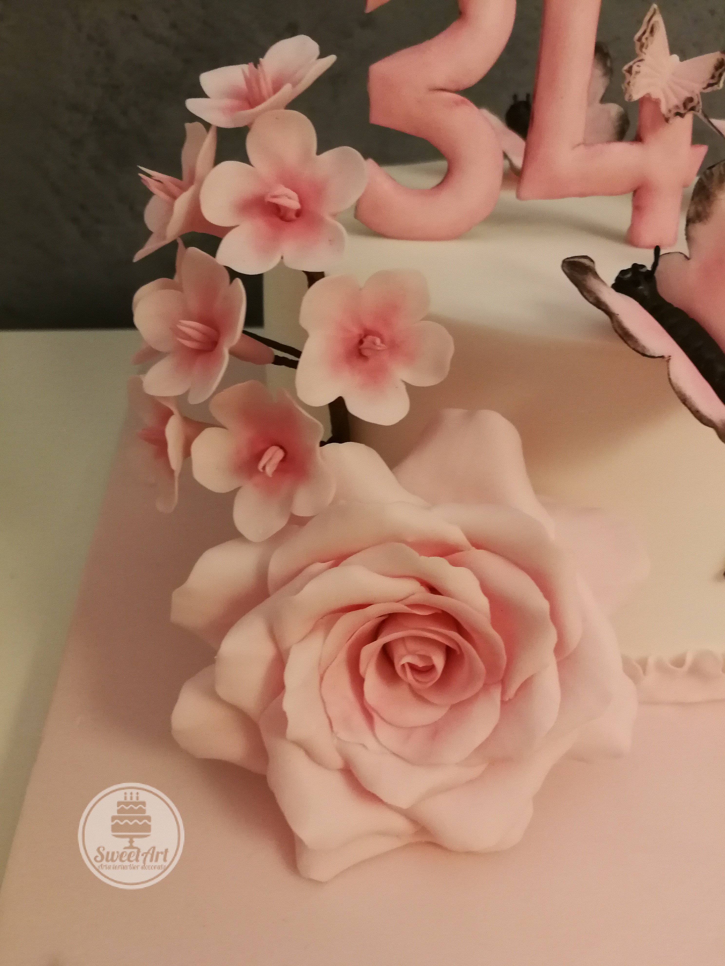 Trandafir roz și o crenguță cu flori de cireș, tort alb-roz-negru cu volănaș - ruffle roz, fluturi și fluturași roz cu negru