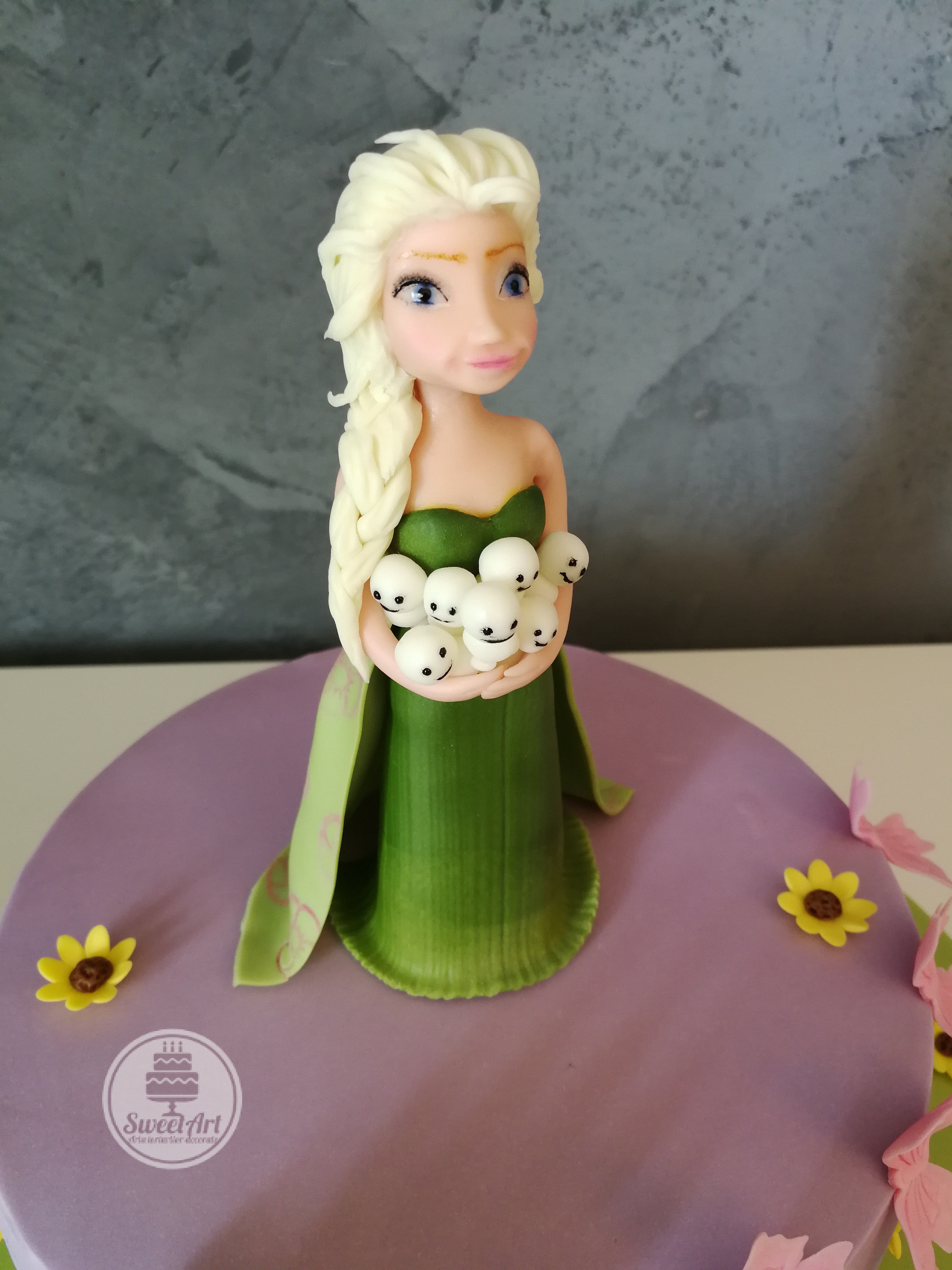 Tort Elsa - Febra Regatului de gheață - Frozen Fever: Elsa în rochie verde smarald cu omuleți de zăpadă în brațe, flori și floricele de floarea soarelui, floricele galbene, tort mov
