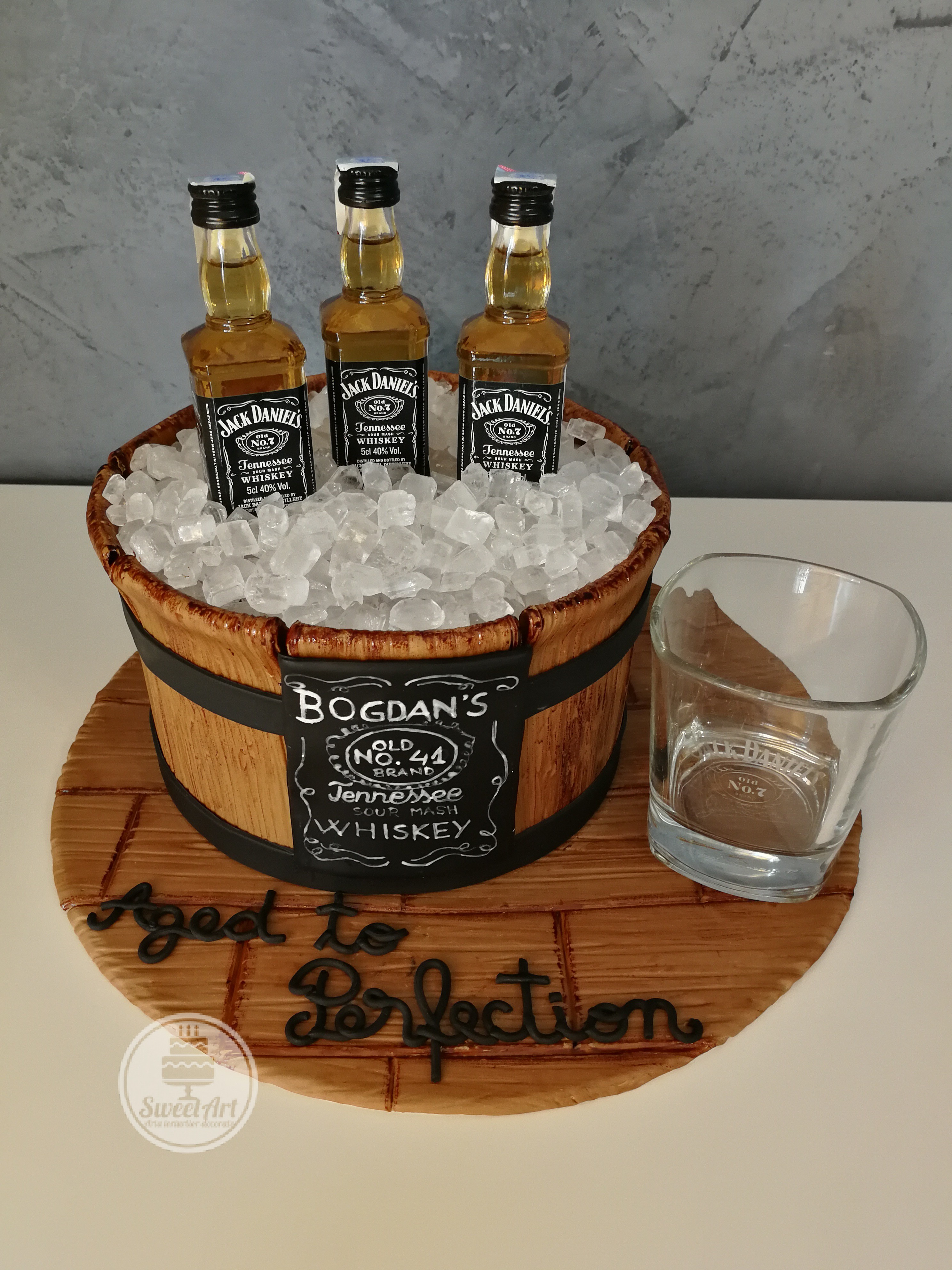 Tort frapieră de lemn cu gheață din zahăr și whiskey Jack Daniel's pe platou de lemn, etichetă pictată manual