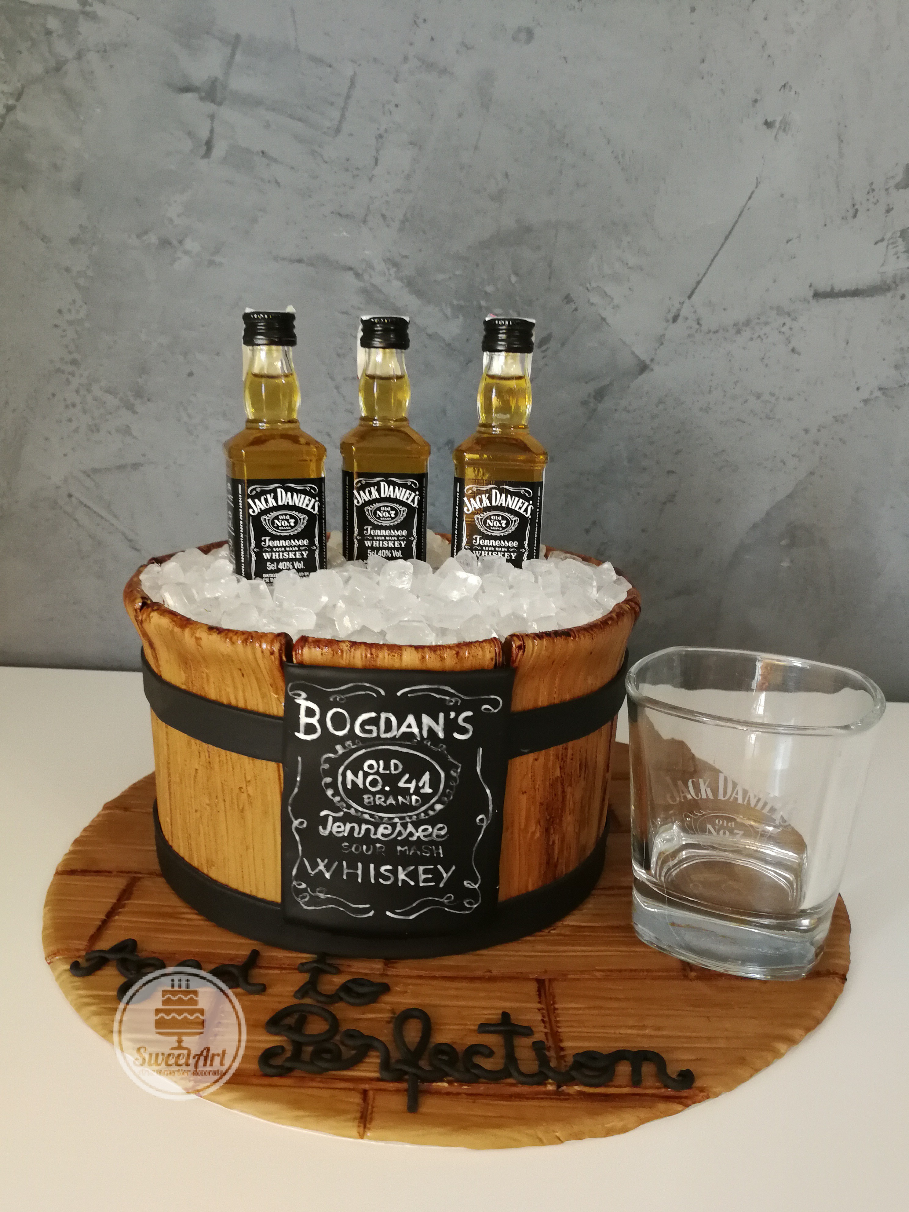 Tort frapieră de lemn cu gheață din zahăr și whiskey Jack Daniel's pe platou de lemn, etichetă pictată manual